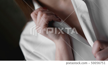 A woman holds her hands for mens white shirt. Photo without face A woman holds her hands for mens white shirt. Photo without face 50056751