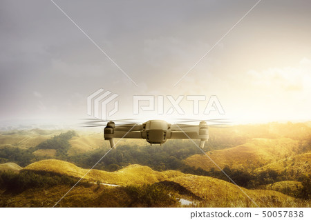 White drone with camera flying above green hills White drone with camera flying above green hills 50057838