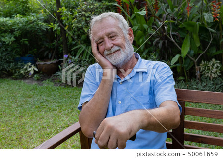 senior man sitting alone in the garden, and try to senior man sitting alone in the garden, and try to 50061659