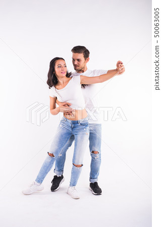 Young couple dancing social latin dance bachata, merengue, salsa. Two elegance pose on white Young couple dancing social latin dance bachata, merengue, salsa. Two elegance pose on white 50063005
