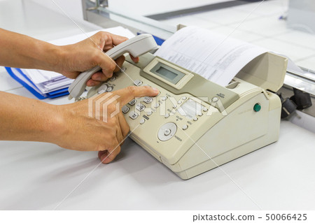 hand man are using a fax machine in the office hand man are using a fax machine in the office 50066425