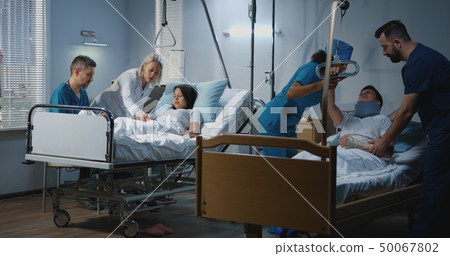Doctors and nurses dealing with patients in hospital 50067802