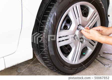 Car Mechanician changing tire car wheel  50067852