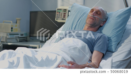 Man lying in hospital bed 50068019