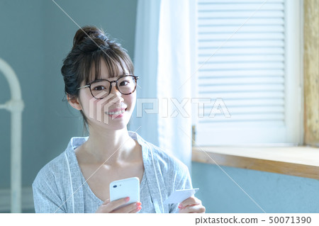 Woman smartphone card shopping 50071390