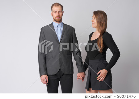 Portrait of young business couple holding hands together 50071470