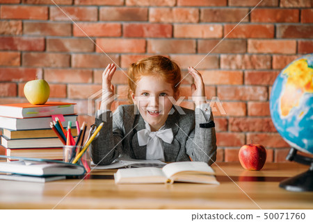 Tired schoolgirl doing homework at the table Tired schoolgirl doing homework at the table 50071760