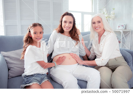 Pregnant woman feeling happy spending time with her family Pregnant woman feeling happy spending time with her family 50071997