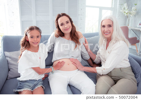 Pregnant woman sitting in the middle between mother and daughter 50072004