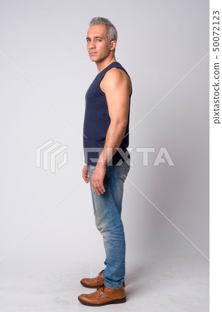 Full body shot profile view of handsome Persian man looking at camera 50072123