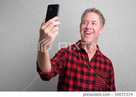 Mature hipster man wearing red checkered shirt Mature hipster man wearing red checkered shirt 50072374