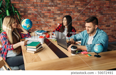 Group of students studying at the table together Group of students studying at the table together 50072491