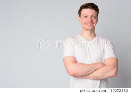 Portrait of happy young handsome man smiling with arms crossed 50072580