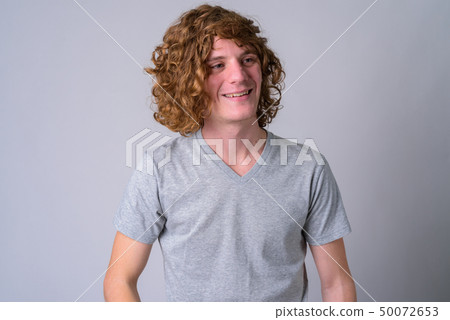 Portrait of happy young handsome man with curly hair thinking Portrait of happy young handsome man with curly hair thinking 50072653