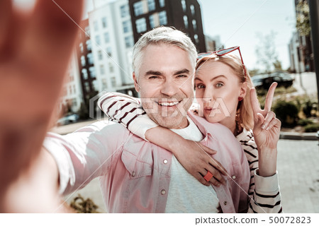 Joyful happy man taking a selfie with his wife 50072823