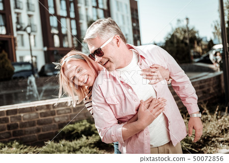 Positive nice woman standing behind her husband 50072856