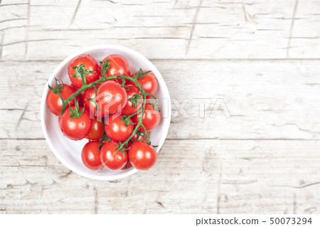 Fresh tomatoes in white bowl on rustic wooden Fresh tomatoes in white bowl on rustic wooden 50073294