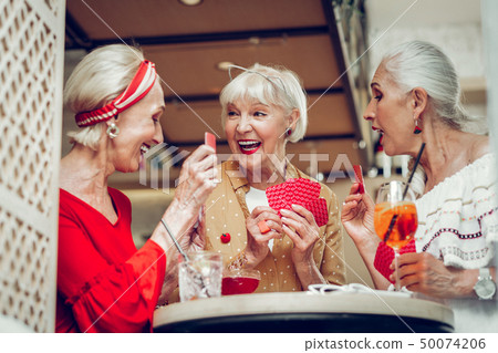 Positive joyful women sitting around the table Positive joyful women sitting around the table 50074206