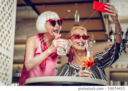 Delighted good looking women taking selfies together 50074455