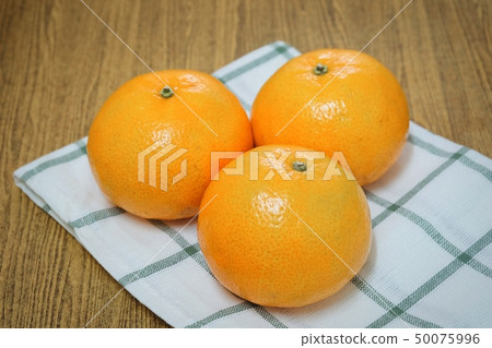 Three Ripe Oranges on A Wooden Table 50075996