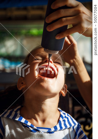 Little boy is drinking chocolate topping in Thailand  50077084