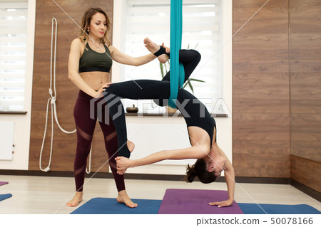 the coach helps the girl in a stretch on a 50078166