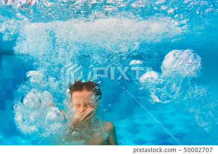 Boy diving in swimming pool 50082707