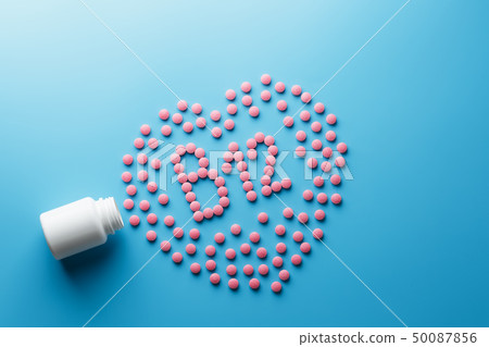 Pink tablets in the form of B12 in the heart on a 50087856