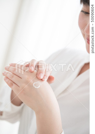 Hand of young Japanese woman applying hand cream 50090604