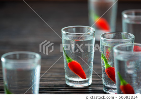 vodka with peppers on wooden table, selectiv vodka with peppers on wooden table, selectiv 50093814