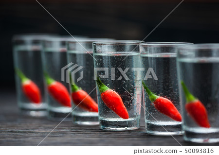vodka with peppers on wooden table, selectiv vodka with peppers on wooden table, selectiv 50093816