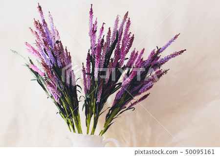 Home interior decor, bouquet of lilacs in a vase and books on rustic wooden table, on a white wall Home interior decor, bouquet of lilacs in a vase and books on rustic wooden table, on a white wall 50095161