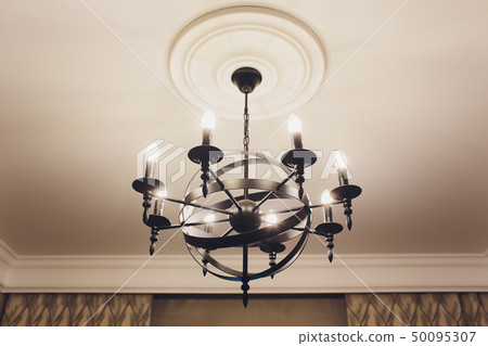 luxury expensive chandelier hanging under ceiling in palace. luxury expensive chandelier hanging under ceiling in palace. 50095307