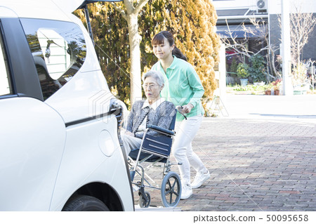 Helper to put the elderly in wheelchair on welfare vehicle 50095658