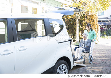 Helper to put the elderly in wheelchair on welfare vehicle 50095659