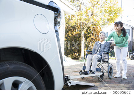 Helper to put the elderly in wheelchair on welfare vehicle 50095662