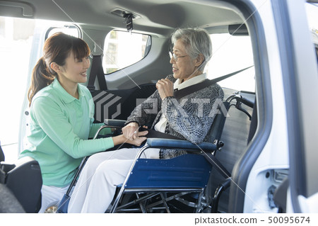 Helper to put the elderly in wheelchair on welfare vehicle Helper to put the elderly in wheelchair on welfare vehicle 50095674