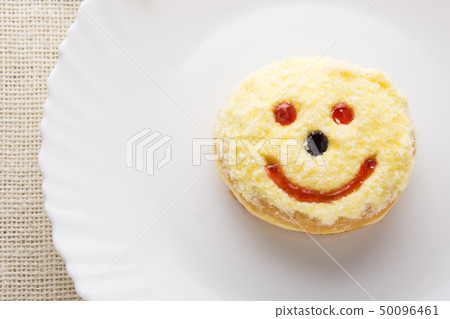 Smiley donut on a white plate Smiley donut on a white plate 50096461