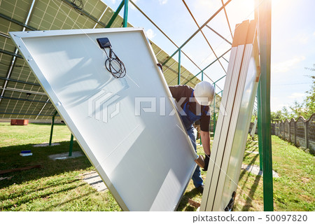 Professional worker wearing white protective helmet, mounting solar pannels on metal construction Professional worker wearing white protective helmet, mounting solar pannels on metal construction 50097820