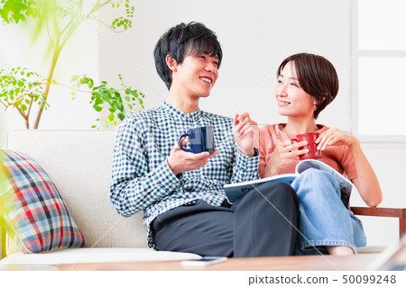 放鬆在長沙發的夫婦夫婦 放鬆在長沙發的夫婦夫婦 50099248