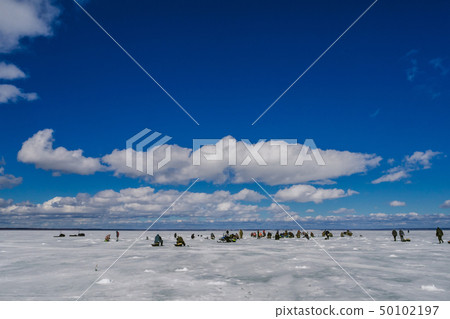 group of fishermen fishing on the ice pond 50102197