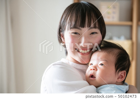 抱著嬰孩日本父母和孩子的一個年輕母親 抱著嬰孩日本父母和孩子的一個年輕母親 50102473