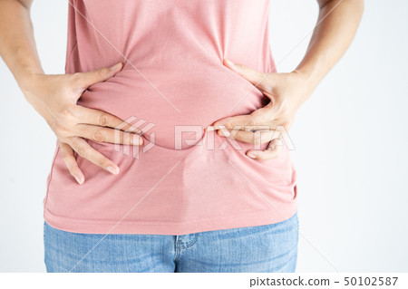 Woman hand holding her own belly fat and cellulite 50102587