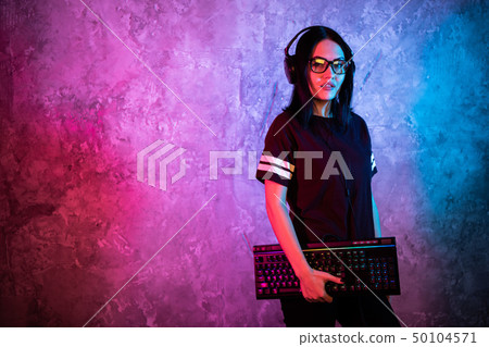 Gamer girl playing with computer at home. Young female posing with computer keyboard. Gamer girl playing with computer at home. Young female posing with computer keyboard. 50104571
