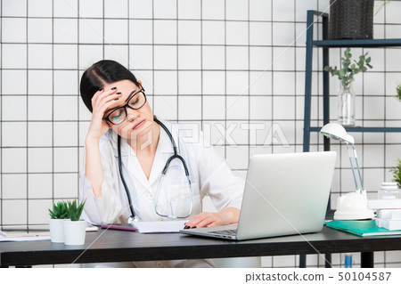 A Muslim Doctor with glasses and stethoscope working with documents on a white background 50104587