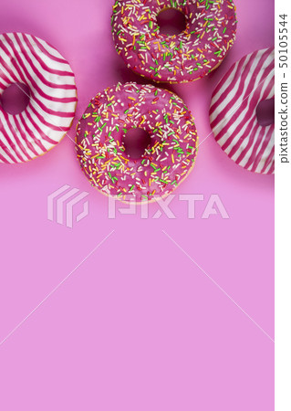Pink donuts on a wooden background. Pink donuts on a wooden background. 50105544