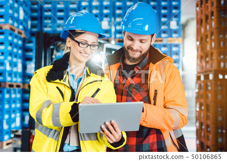 Woman and man as workers in logistics center using computer 50106865
