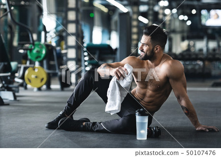 Handsome young muscular sportsman resting after workout 50107476