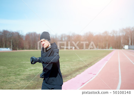 Image of sportsman running through stadium during spring jog. 50108148