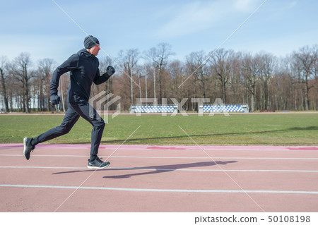 Photo on side of athlete man running through stadium during spring jog Photo on side of athlete man running through stadium during spring jog 50108198